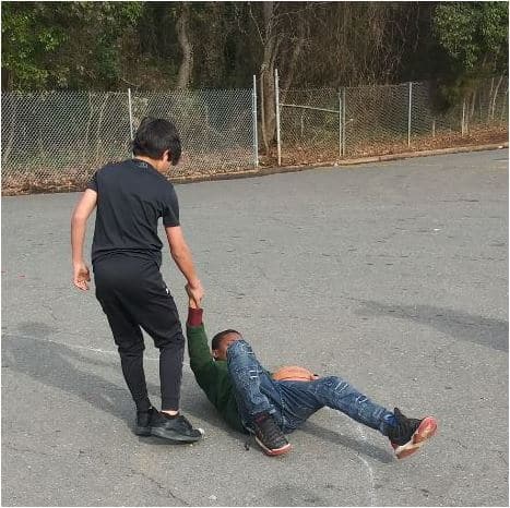 Teenage boy helps a friend after playing sports together. 